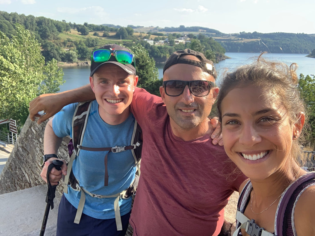 Tre pellegrini sorridenti in un selfie durante una tappa del Cammino di Santiago