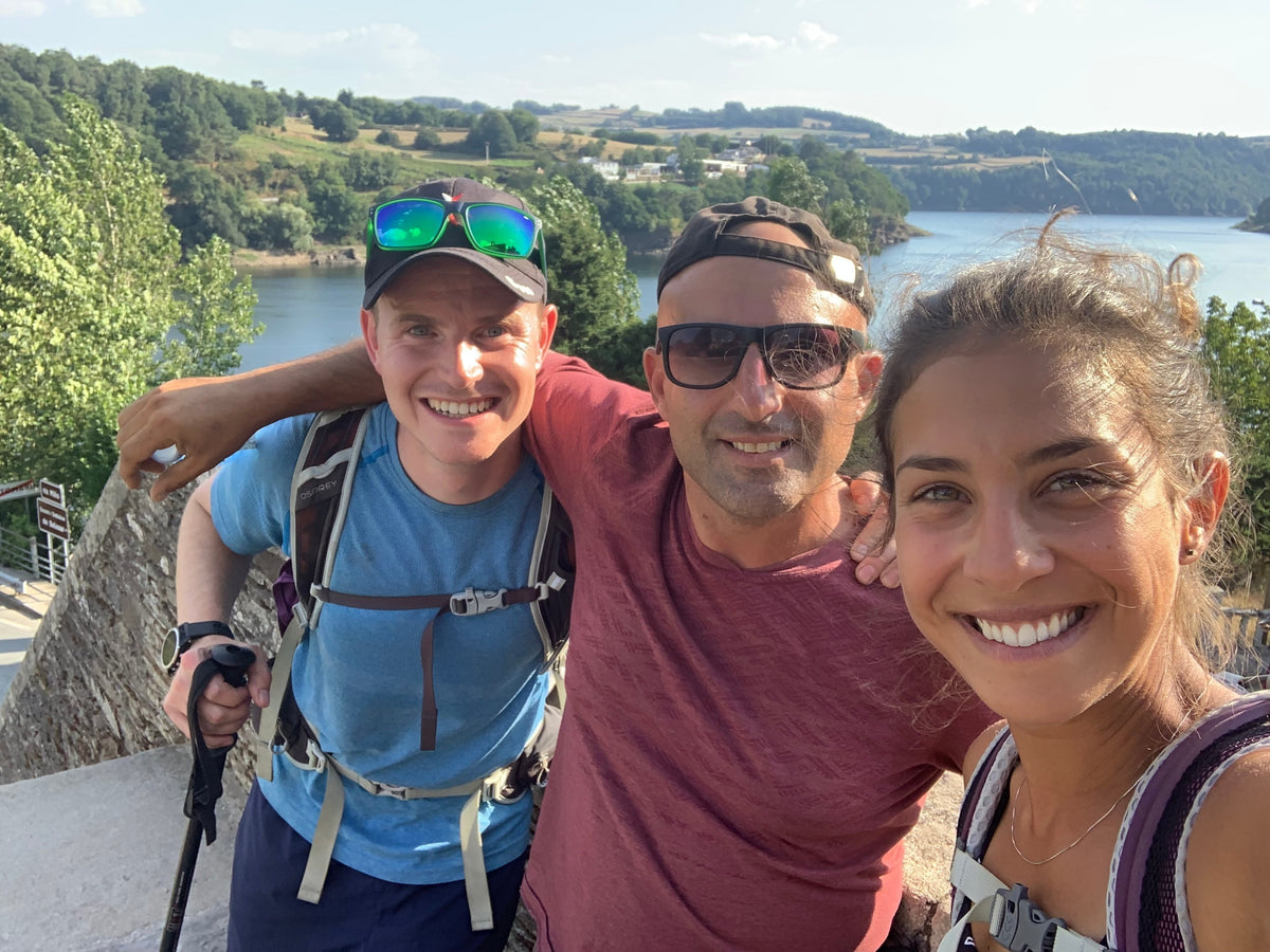 Tre pellegrini sorridenti in un selfie durante una tappa del Cammino di Santiago