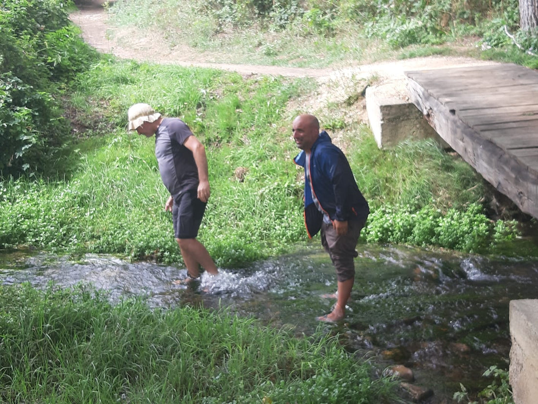 Pellegrini con i piedi immersi in un ruscello per prevenire le vesciche